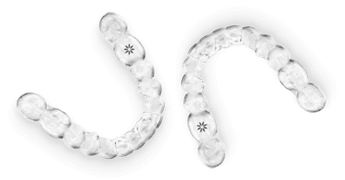 Clear plastic dental aligners with tooth-shaped markers arranged in curved rows on white background.